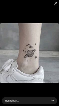 a small saturn tattoo on the ankle