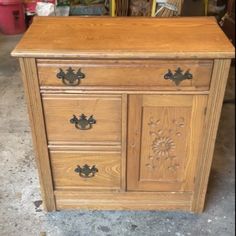 an old wooden dresser with metal handles and knobs on the doors, in a garage