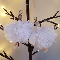 two ornaments hanging from a tree decorated with lights