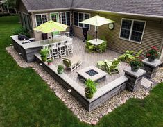 an outdoor patio with chairs, tables and umbrellas on the side of a house