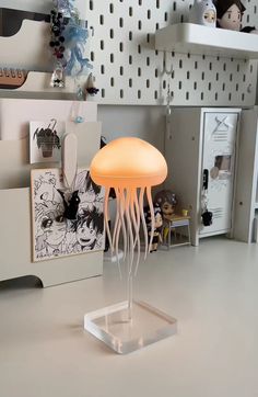 a jellyfish lamp sitting on top of a white table next to a toy doll