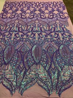 purple and green sequin lace on a white tablecloth with blue trimmings