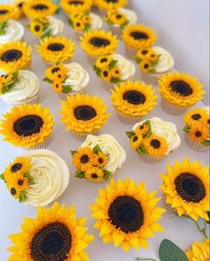 cupcakes and sunflowers are arranged on a table