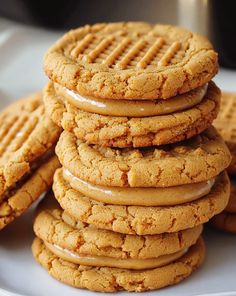 a stack of peanut butter cookies on a white plate