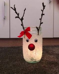 a glass jar with some branches sticking out of it and a red nose on top