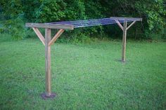 a wooden table sitting on top of a lush green field