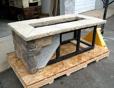 a table made out of concrete sitting on top of a pallet next to a building