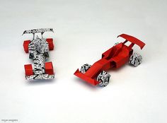 two red and white paper cars sitting next to each other