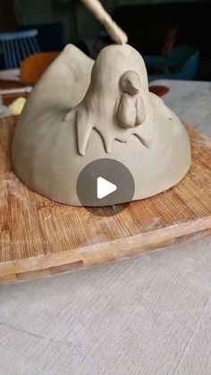 a clay sculpture of a sleeping dog on a cutting board with a wooden stick in it's mouth