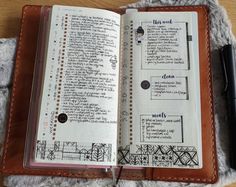 an open bible on top of a table next to a pen and paper with writing