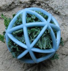 a close up of a ball made out of kale and other greens on the ground