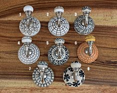 six different door knobs on a wooden surface with numbers in the center and bottom