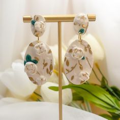 Step into summer with our exquisite Evangeline Earrings, where artistry and elegance bloom. Crafted from polymer clay, each earring showcases intricate 3D floral designs adorned with delicate gold leaf accents, capturing the essence of a summer garden in full bloom. The hypoallergenic gold filled posts ensure comfort for all-day wear, making them perfect for summer outings, weddings, and special events where you want to shine. Elegant Floral Print Earrings, Elegant Hand Painted Gold Earrings, Gold Jewelry With 3d Flowers In Polymer Clay, Gold Polymer Clay Flower Earrings As Gift, Gold Polymer Clay Jewelry With 3d Flowers, Elegant Floral Print Drop Earrings, Handmade Gold Flower Earrings In Polymer Clay, Gold Flower-shaped Polymer Clay Earrings, Handmade Gold Polymer Clay Flower Earrings