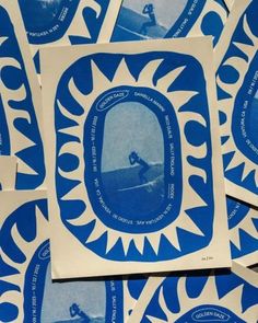 several blue and white stickers with surfers in the middle one is on a surfboard