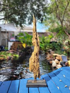 a piece of wood that is sitting on top of a blue wooden deck next to water