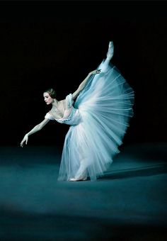 a ballerina is dressed in white and posing for the camera