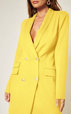 This blazer dress will give you a fierce look with tons of attitude. Featuring a classic fabric with an asymmetric design and gold button detailing, style with gold heels and a pendant necklace for a chic weekend vibe.