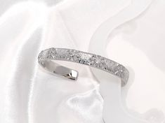 Luxurious Elegance in Every Curve 💎 Stunning Design: Crafted with a delicate snowflake pattern, this bangle catches the light with its sparkling crystals. 🔗 Adjustable Fit: No matter your wrist size, enjoy a custom fit with the bangle's flexible design. Timeless Craftsmanship 🛠️ High-Quality Material: Plated with 18K white gold for a durable and luxurious finish. 🌟 Versatile Style: Perfect for dressing up everyday outfits or adding a touch of sophistication to your evening wear. Perfect for Every Occasion 🎉 Party-Ready: The ideal accessory for weddings, proms, or any festive occasion. Additional Features 📏 One Size Fits All: Effortlessly adjust to fit your wrist comfortably. 🌐 Globally Inspired: A retro style with a modern twist, appealing to fashion enthusiasts around the world. ✨ Modern White Gold Cuff Bracelet With Shiny Finish, White Gold Cubic Zirconia Cuff Bracelet Bangle, Luxury White Gold Polished Cuff Bracelet, Elegant White Cubic Zirconia Bangle, Elegant White Gold Cuff Bracelet With Pave Setting, Gold Snowflake, Open Bangle, Chic Party, Spring Jewelry