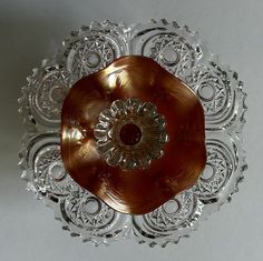 a decorative glass dish with an intricate design on it's center piece, in the shape of a flower