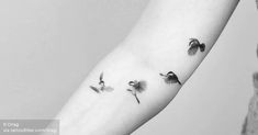 three birds flying in the air on someone's arm