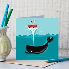 there is a card with a whale and a boat in the water on it's side