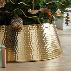 a christmas tree in a gold pot with ornaments