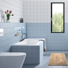 a bathroom with blue tile walls and flooring next to a bathtub, toilet and sink