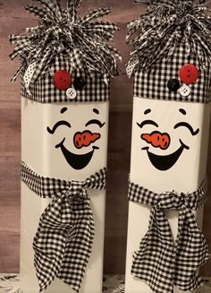 two white boxes decorated with black and white checkered fabric, one has a clown face painted on it