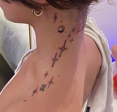 a woman's neck with stars and moon tattoos on her left side ribcage