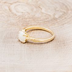 a gold ring with a white stone on it