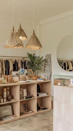 an open closet with clothes hanging from the ceiling and mirrors on the wall above it