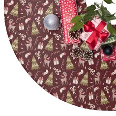 christmas wrapping and presents on a table with pine cones, holly leaves, baubles and ornaments