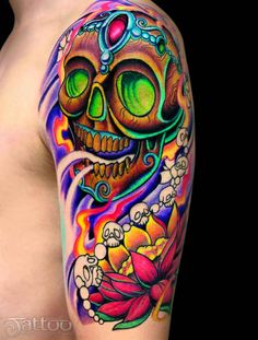 a colorful tattoo with a skull and flowers on it