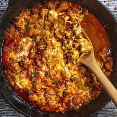 a skillet filled with food and a wooden spoon