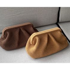 two purses sitting next to each other on a couch