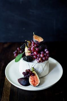 a piece of cheese topped with grapes and figs