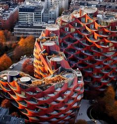 an aerial view of two buildings in the city with orange and red architecture on top