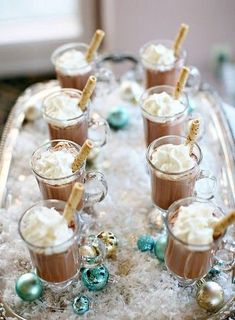 small cups filled with hot chocolate and marshmallows on top of a tray