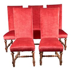 four red velvet chairs with wooden legs