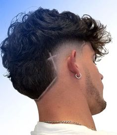 Fluffy Mullet Fade with Fringe and Design. This modern mullet hairstyle is a trendy and stylish take on the iconic cut, offering a fresh look that will stand out for the right reasons. With a balanced approach, the popular men’s haircut can blend classy and edgy to make an attractive statement. Experiment with a new style by asking your barber for a contemporary variation. Fade Haircut Line Design, Burst Fade With Cross Design, Mens Burst Fade Haircut Short, Hair Lining For Men, Fade Lines Haircut, Men Haircut With Design, Burst Fade Mohawk With Design, Hair Line Designs For Men, Line In Haircut Men