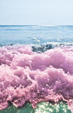 the water is pink and green with some white foam on it's surface, as seen from above