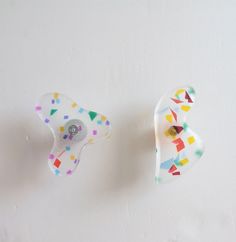 two pieces of glass with confetti and sprinkles on them sitting next to each other