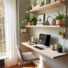 a desk with a laptop computer on top of it next to a plant filled window