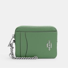 a small green wallet with a chain hanging from it's front pocket and the word coach on the front