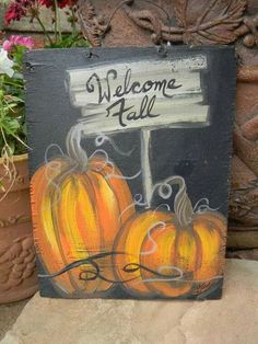 a welcome fall sign with pumpkins painted on it