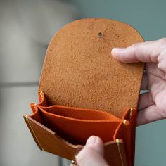 The Juno wallet is perfect for cards and cash. It has 3 sections total with the middle section being perfect for loose change. The coins won't fall out! Promise. Exterior is made from our American-made oil tanned leather in tan. Accents in peach suede. Brass button closure. Measures 4" wide by 3" high. Cognac Trifold Wallet With Card Slots For Everyday Use, Orange Leather Wallet As Gift, Orange Leather Wallet For Daily Use, Leather Trifold Coin Purse With Card Slots, Cognac Wallets With Interior Card Slots, Orange Wallet With Card Slots For Daily Use, Leather Wallet With Coin Pocket In Cognac, Orange Leather Wallet With Card Slots, Orange Leather Wallets With Interior Card Slots