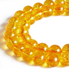 yellow glass beads are arranged on a white surface