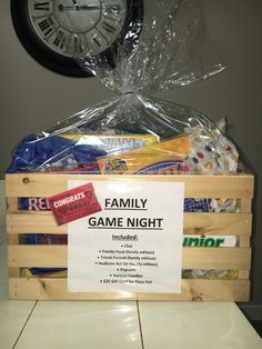 a game night basket with candy, candies and other snacks in front of a clock