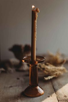 a lit candle sitting on top of a wooden table