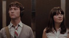 two people standing next to each other with headphones on